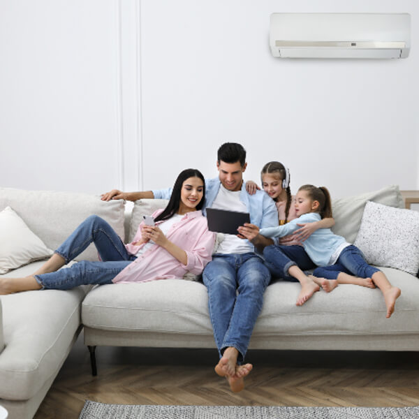 Glückliche Familie vor Klima-Innengerät